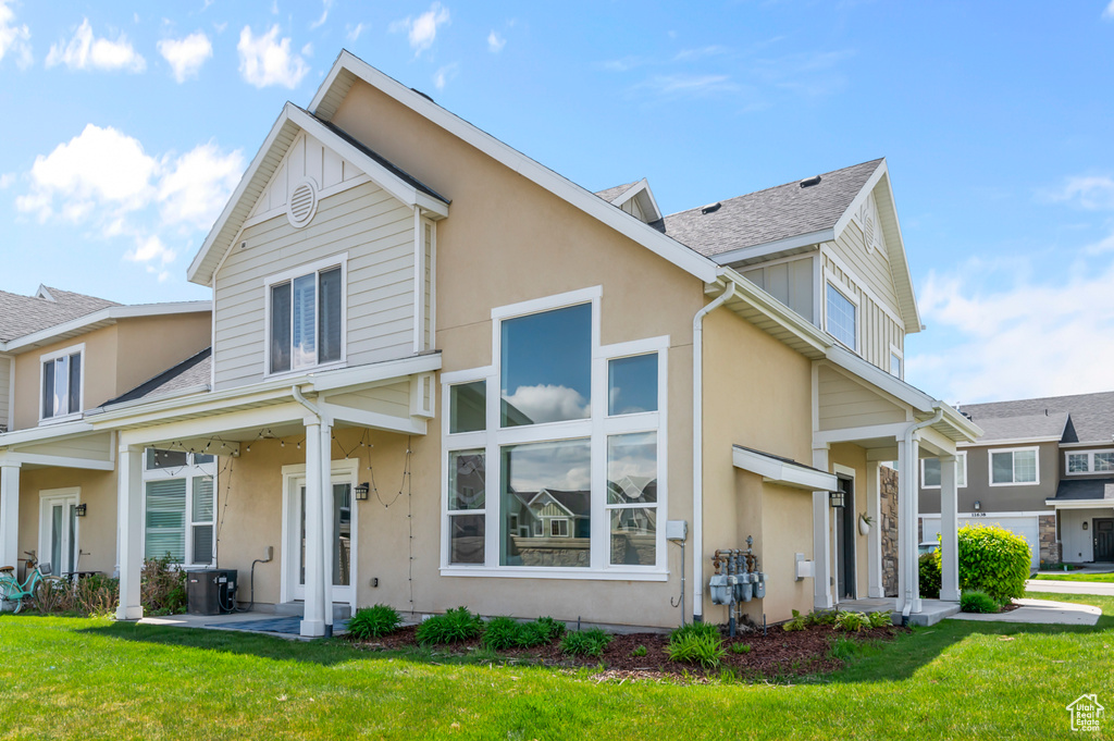 View of front of property with roof with shingles, stucco siding, and a front yard
