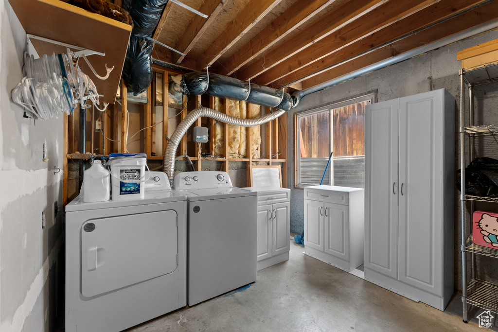 Laundry area featuring separate washer and dryer and cabinet space