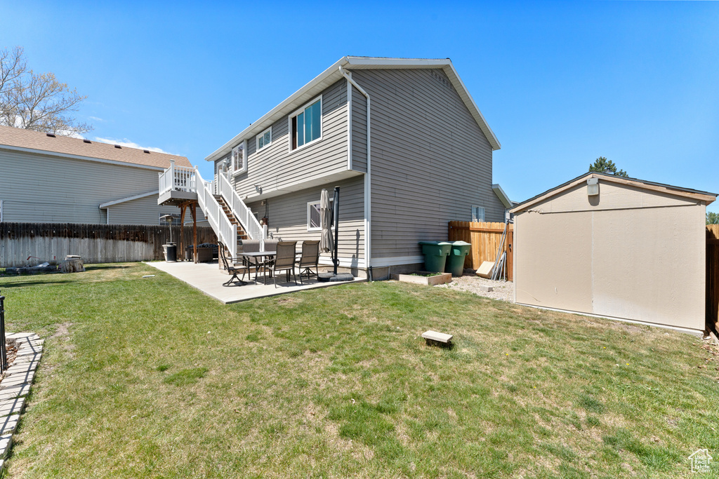 Back of property featuring a fenced backyard, a yard, and a patio area