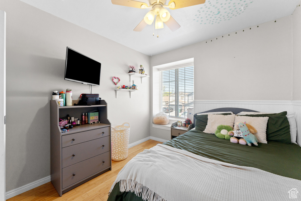 Bedroom featuring light wood-style floors, baseboards, and ceiling fan
