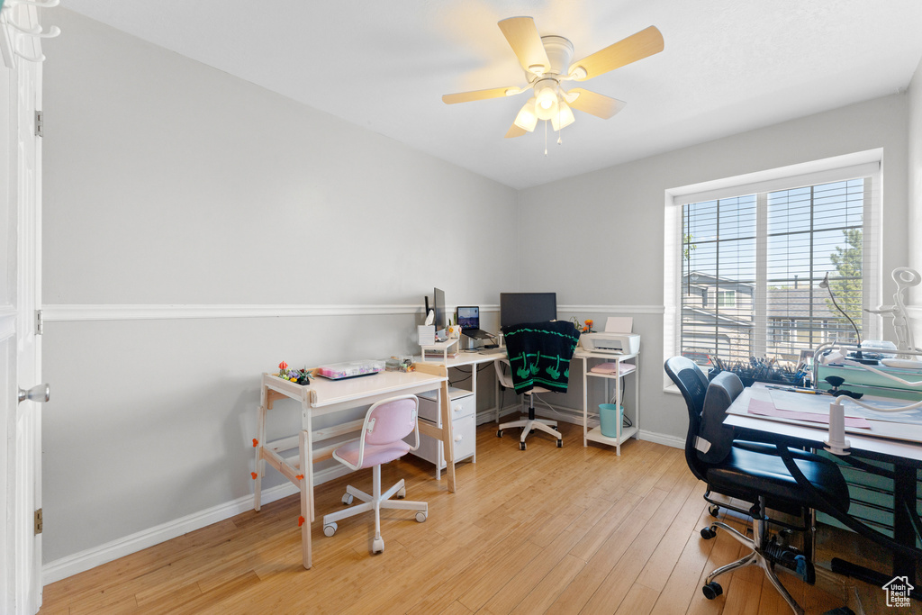 Office with baseboards, a ceiling fan, and light wood-style flooring