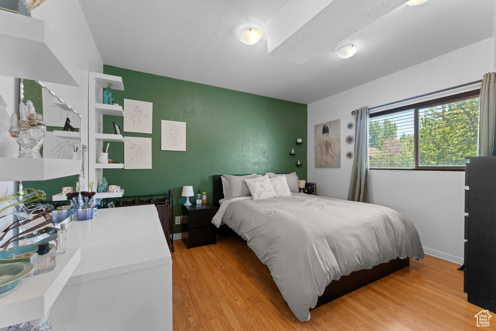 Bedroom with light wood-style flooring and an accent wall