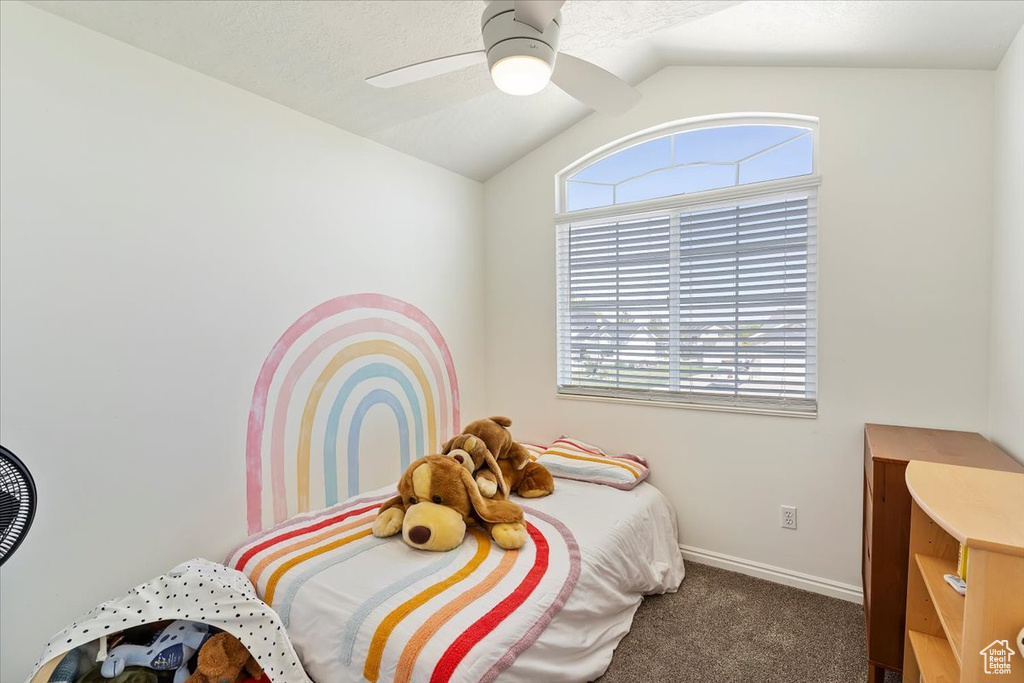Carpeted bedroom featuring baseboards, ceiling fan, and lofted ceiling