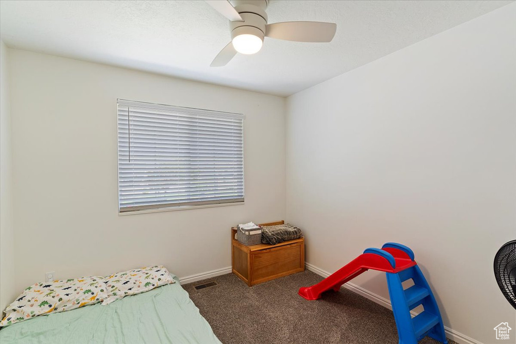 Bedroom with carpet floors, baseboards, a ceiling fan, and visible vents
