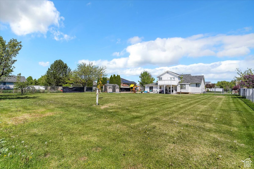 View of yard featuring fence, an outbuilding, and a shed