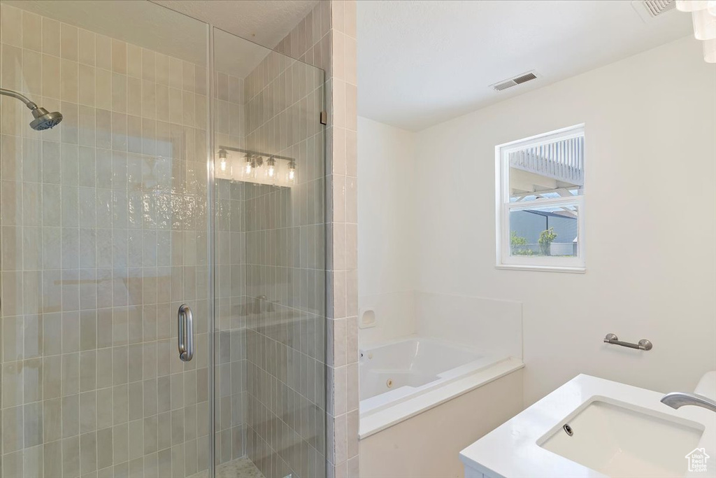 Full bathroom with a tub with jets, visible vents, a shower stall, and a sink