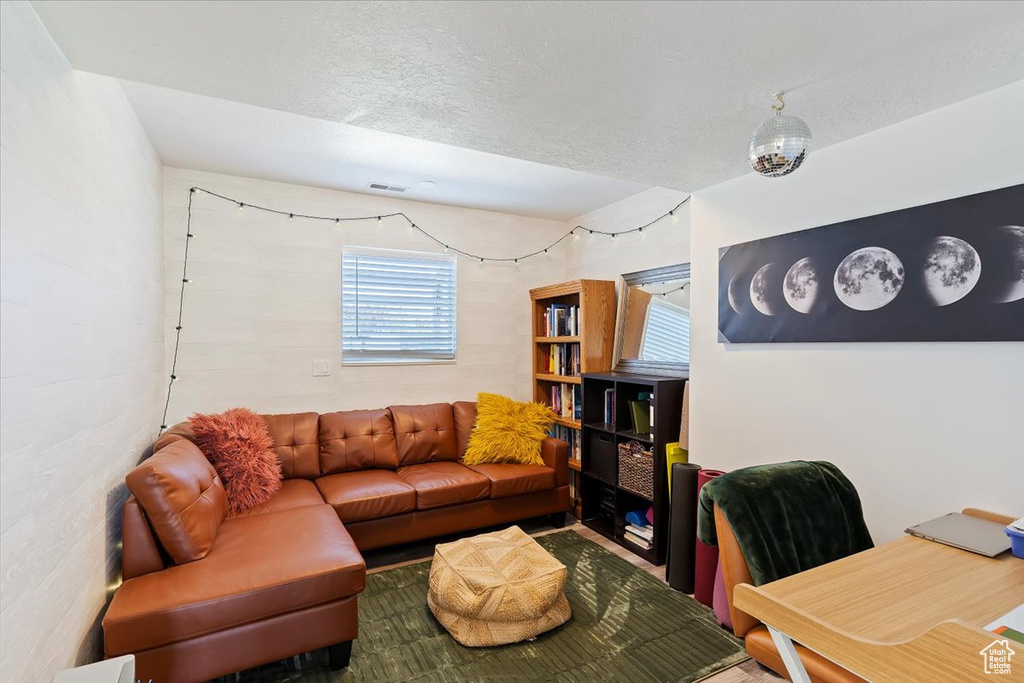 Living room with a textured ceiling and visible vents