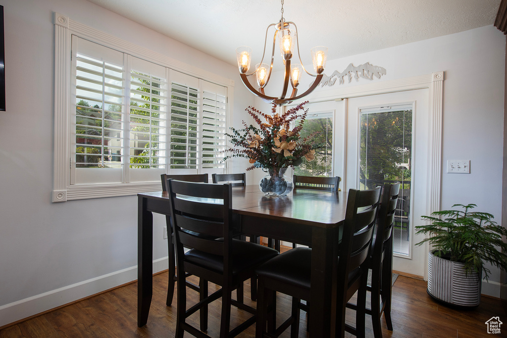 Dining room with an inviting chandelier, baseboards, and wood finished floors