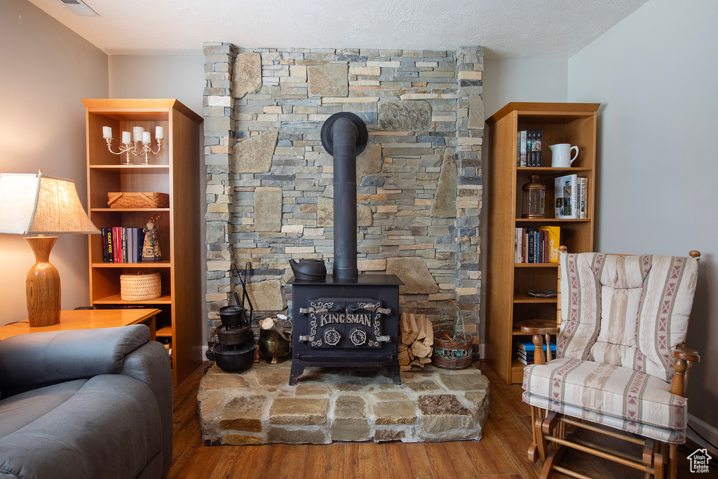 Living area with a wood stove and wood finished floors