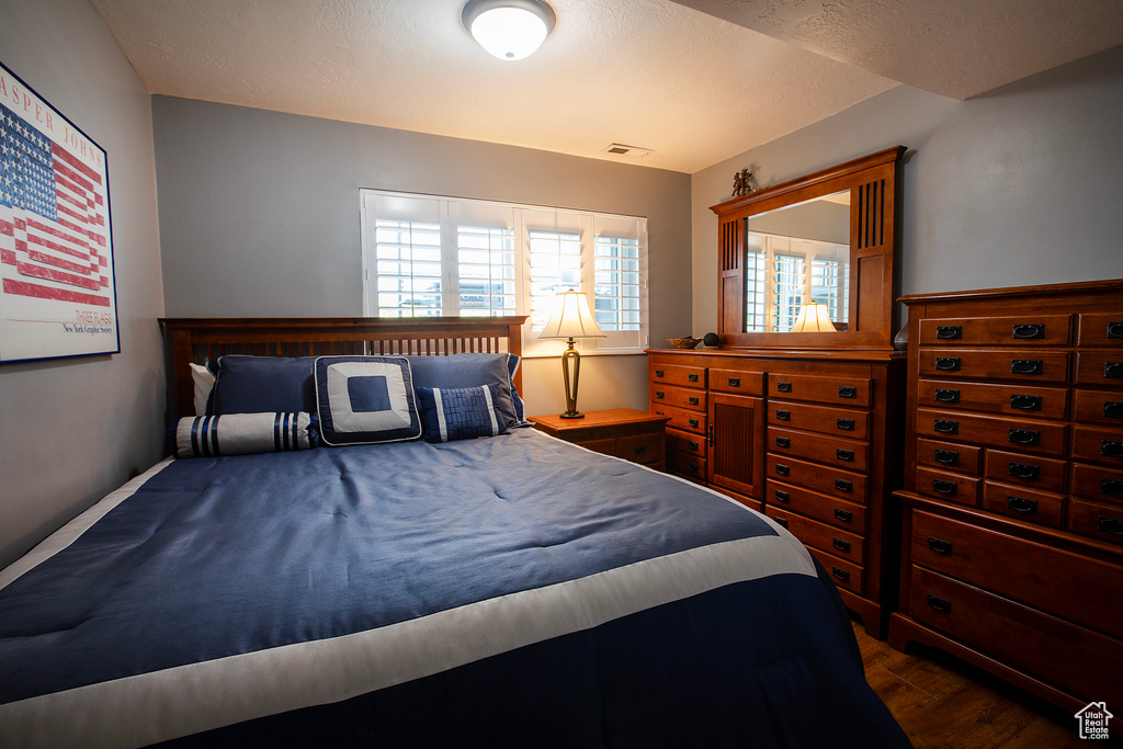 Bedroom with visible vents and dark wood-style floors