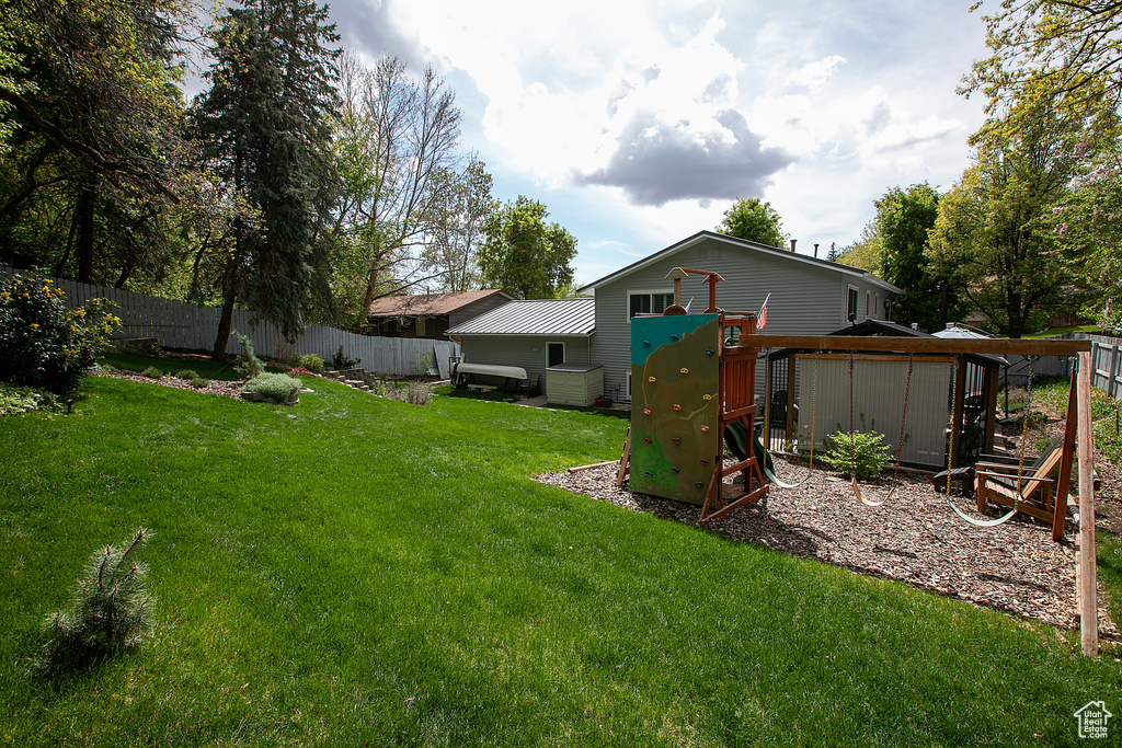 View of yard featuring fence and a playground