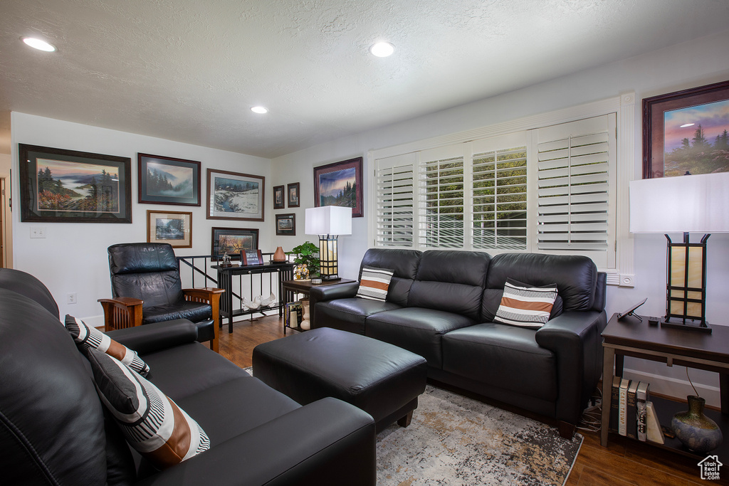Living room with recessed lighting, a textured ceiling, and wood finished floors
