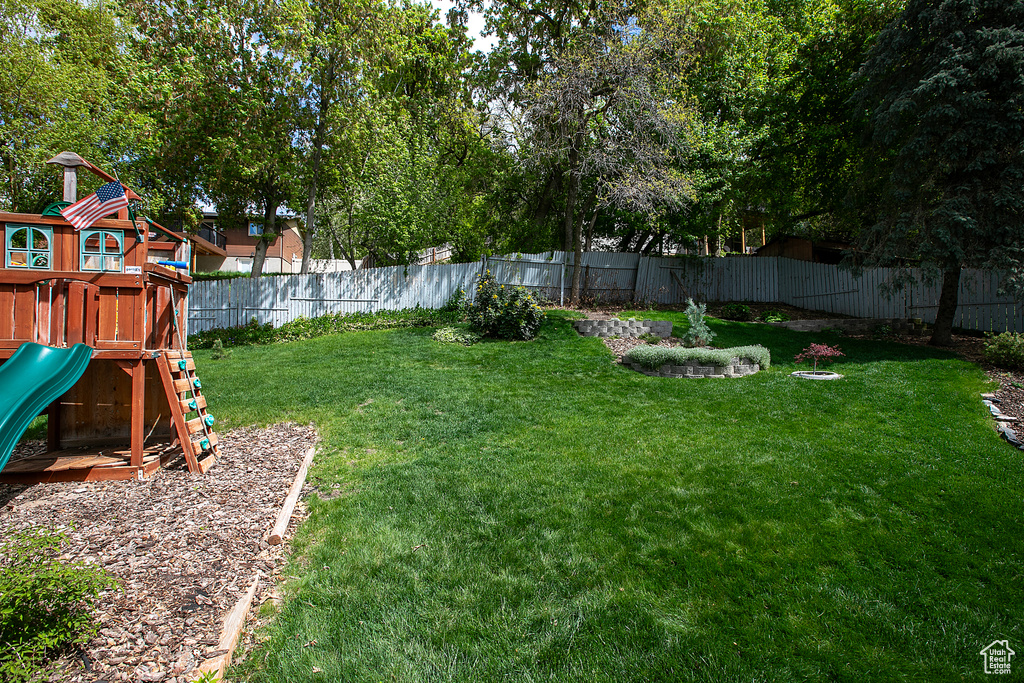View of yard featuring a playground and a fenced backyard