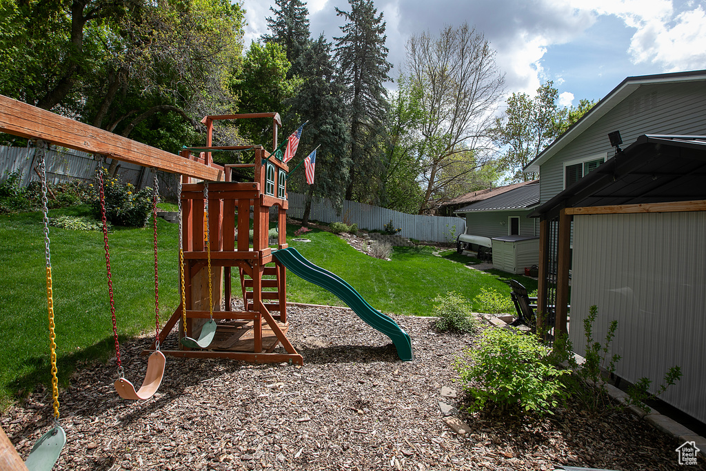 View of jungle gym featuring a lawn and a fenced backyard