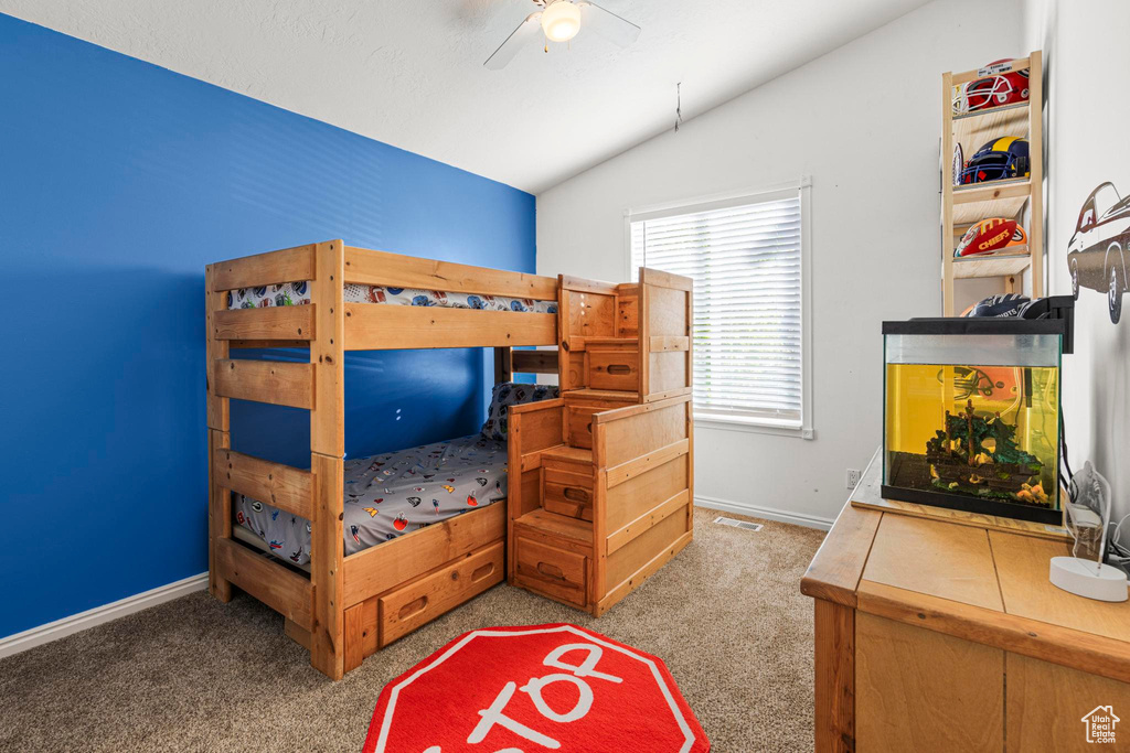 Carpeted bedroom featuring baseboards, ceiling fan, and vaulted ceiling