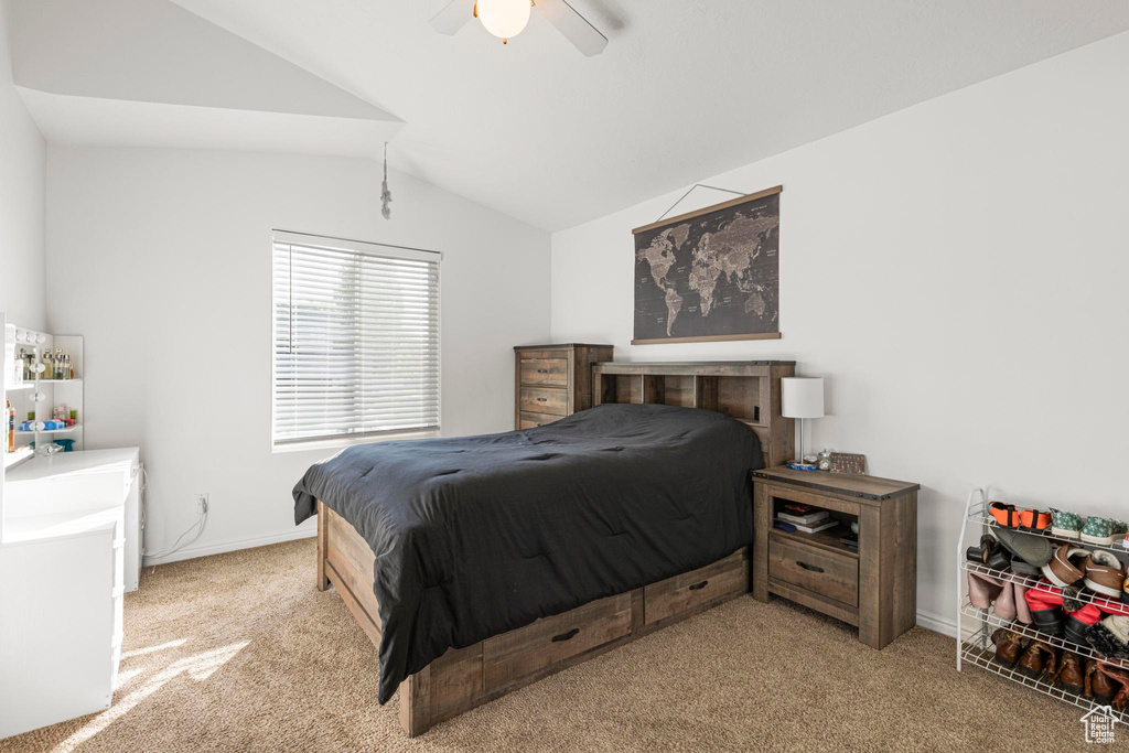 Bedroom featuring baseboards, ceiling fan, light carpet, and lofted ceiling