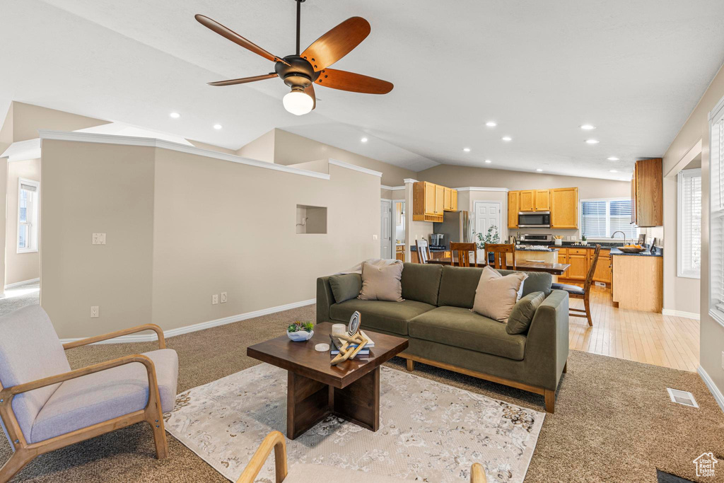 Living area with visible vents, ceiling fan, recessed lighting, light colored carpet, and vaulted ceiling