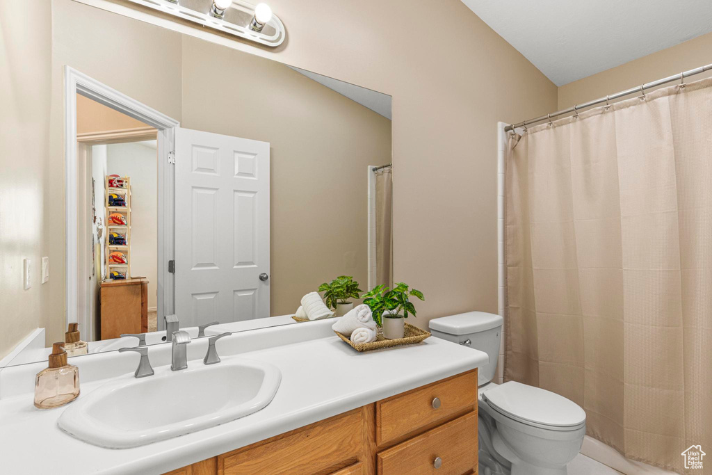 Bathroom featuring vanity, a shower with curtain, and toilet