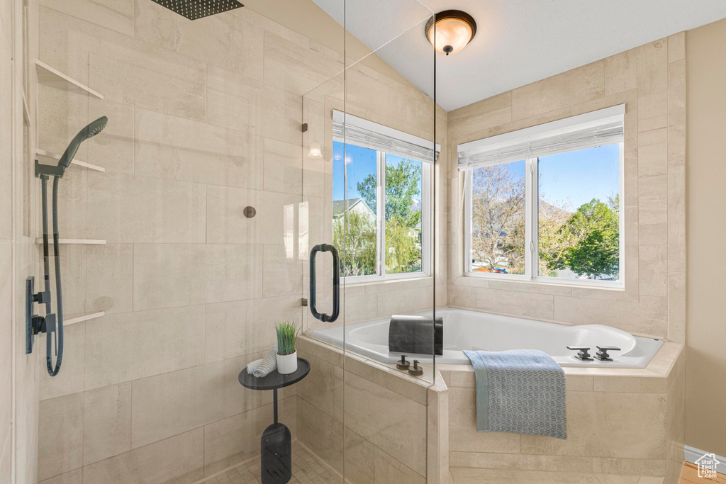 Bathroom with a shower stall, a healthy amount of sunlight, and a garden tub
