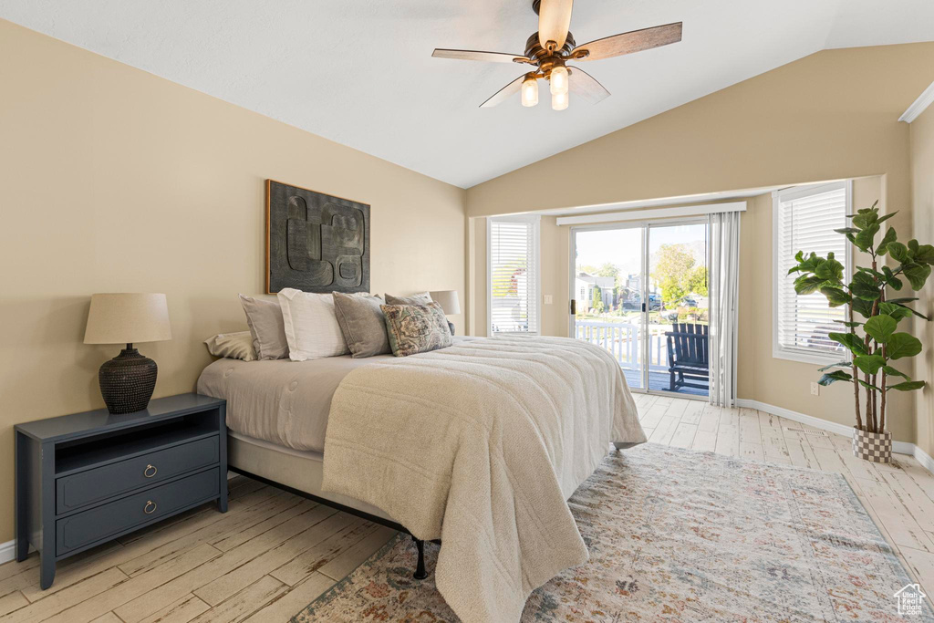 Bedroom with access to outside, baseboards, vaulted ceiling, and light wood-style floors