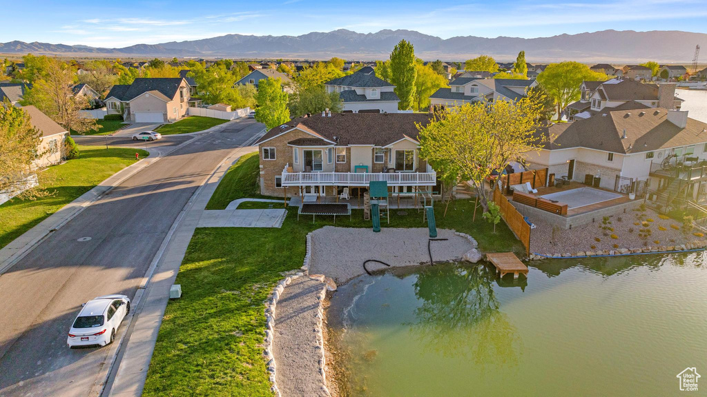 Drone / aerial view featuring a water and mountain view and a residential view