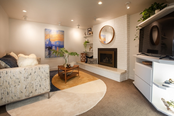 Living area with carpet flooring, recessed lighting, and a brick fireplace