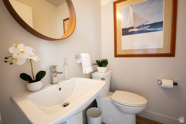 Bathroom featuring baseboards, a sink, and toilet