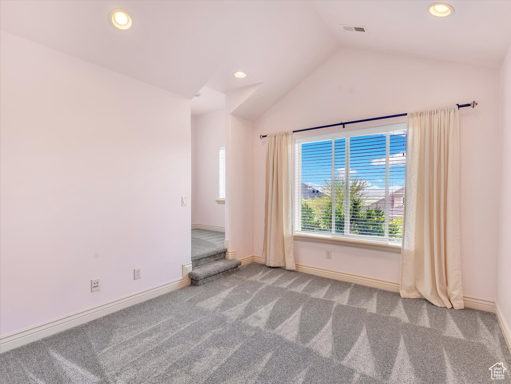 Spare room featuring carpet flooring, recessed lighting, vaulted ceiling, and visible vents