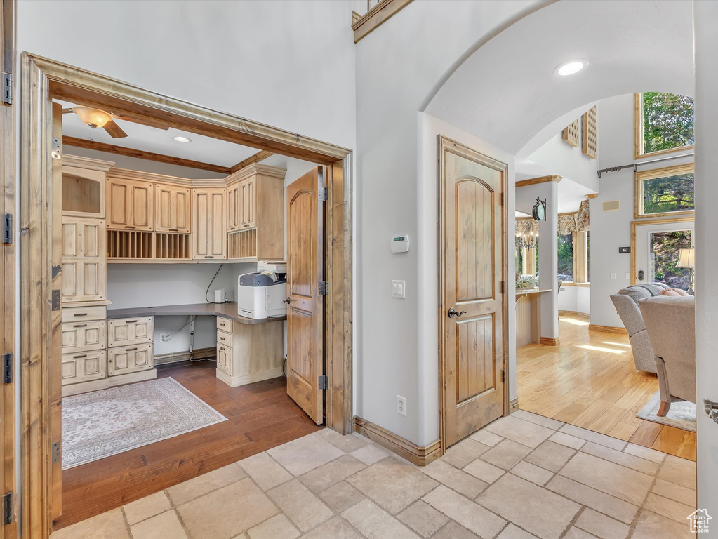 Bathroom with baseboards, ceiling fan, wood-type flooring, and a towering ceiling