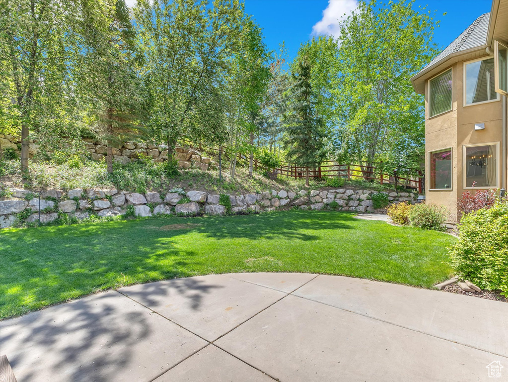 View of yard with fence and a patio area