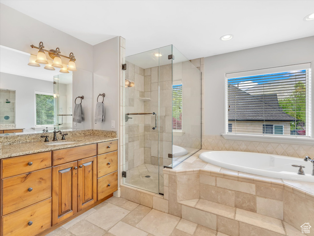 Bathroom with vanity, recessed lighting, a garden tub, and a stall shower