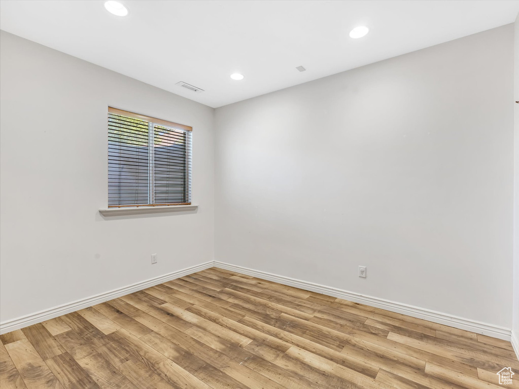Empty room featuring recessed lighting, baseboards, visible vents, and light wood-style flooring