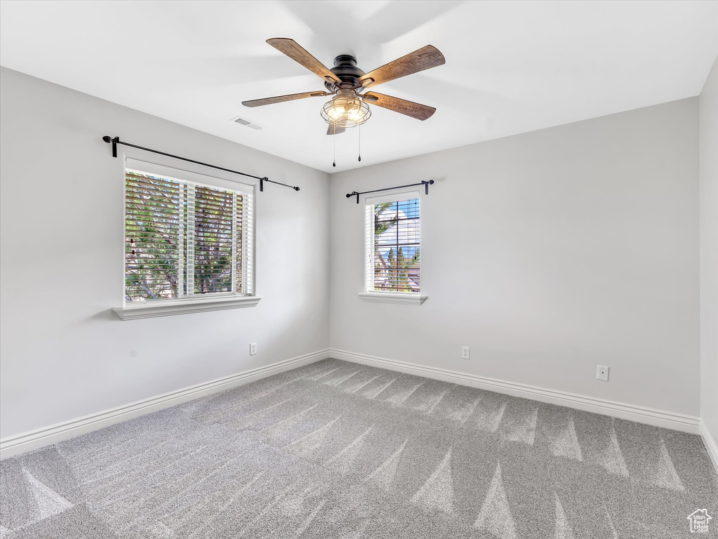 Spare room featuring baseboards, a ceiling fan, and carpet flooring