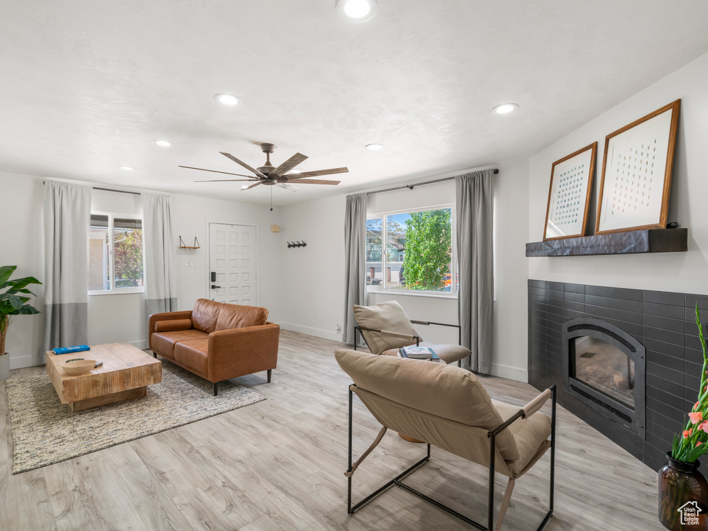 Living room featuring a healthy amount of sunlight, baseboards, recessed lighting, and a tile fireplace