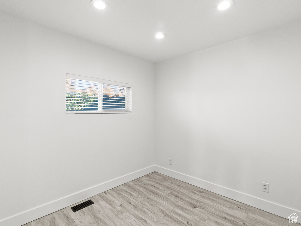 Empty room with baseboards, recessed lighting, light wood-style flooring, and visible vents