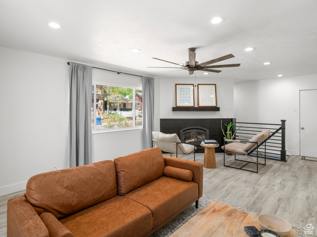 Living area with a brick fireplace, recessed lighting, and light wood-style floors