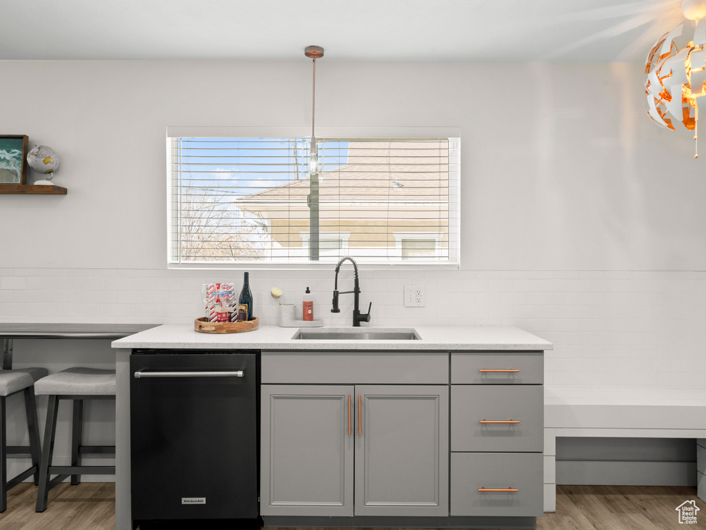 Kitchen featuring a sink, gray cabinets, light wood-style flooring, and dishwasher