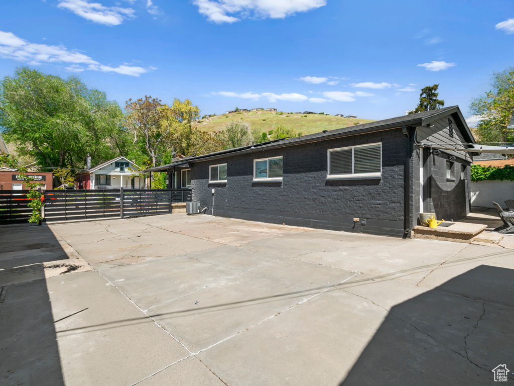 Exterior space featuring central air condition unit, fence, a patio, and a gate