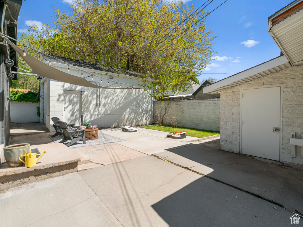 View of patio / terrace with fence, a fire pit, and an outdoor structure