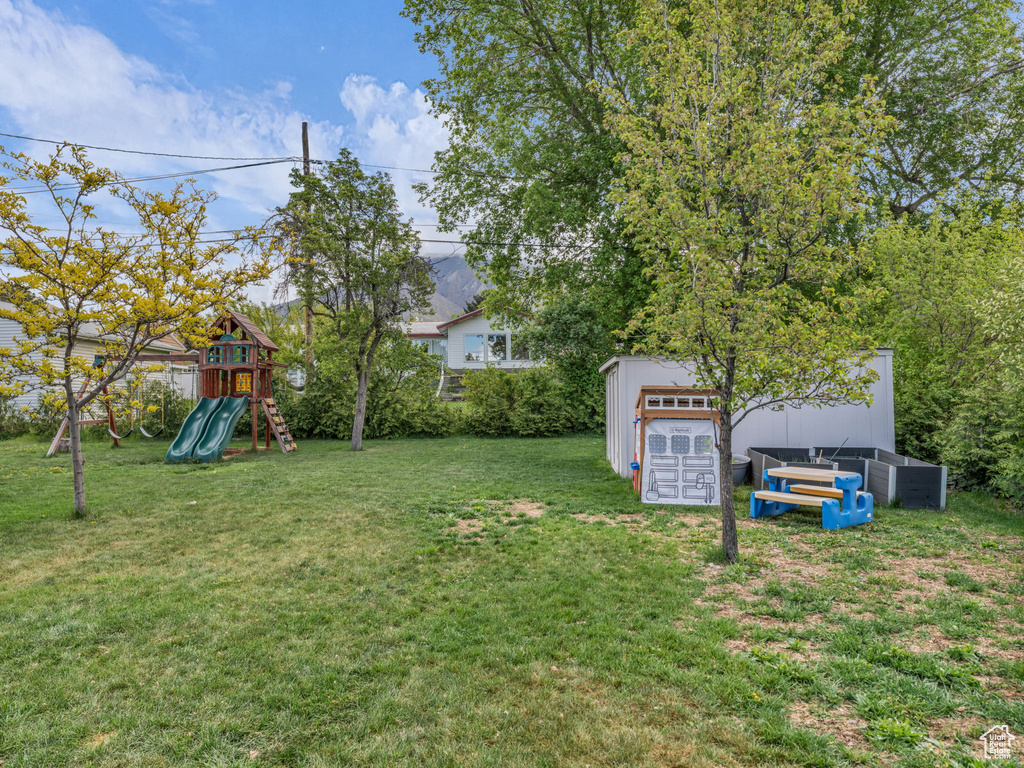 View of yard featuring a storage shed, an outbuilding, and a playground