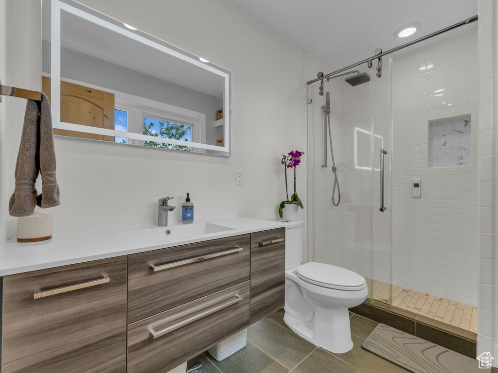 Full bath with vanity, a stall shower, tile patterned floors, and toilet