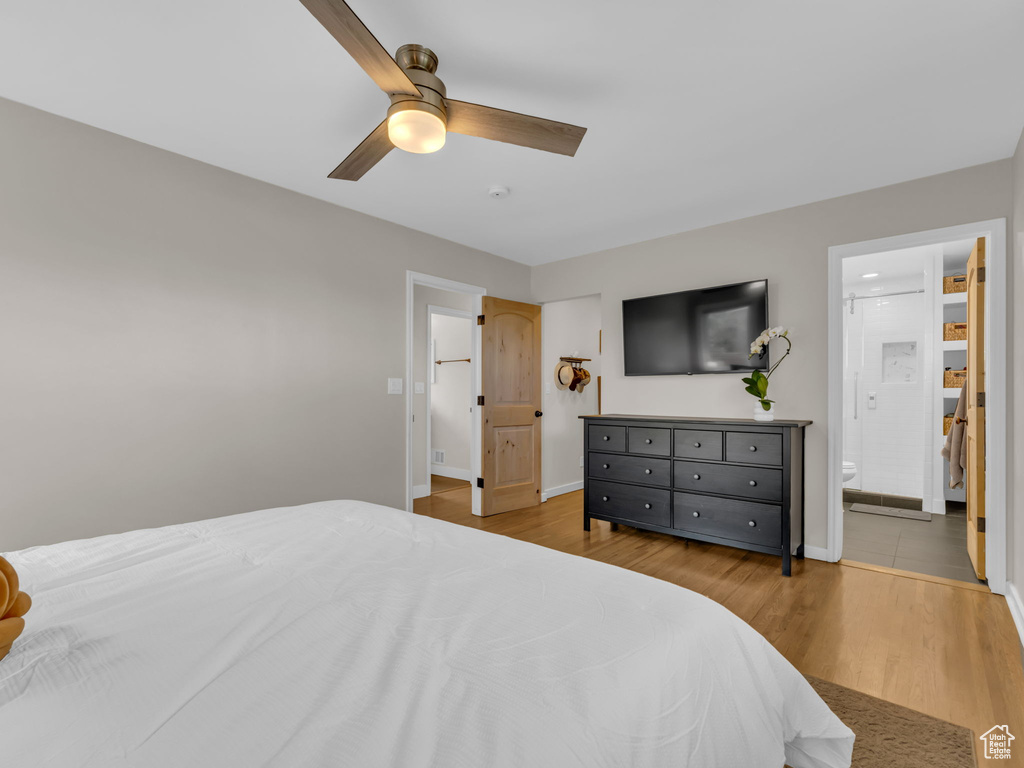 Bedroom featuring baseboards, ceiling fan, ensuite bathroom, and wood finished floors
