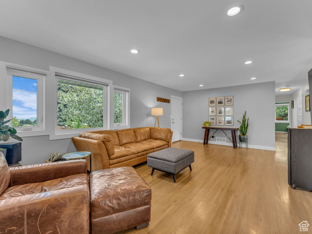 Living room with baseboards, recessed lighting, and light wood-style flooring