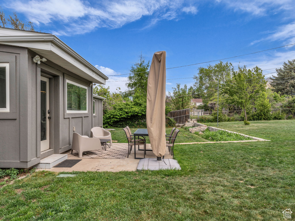 View of yard featuring a patio area, fence, and a garden