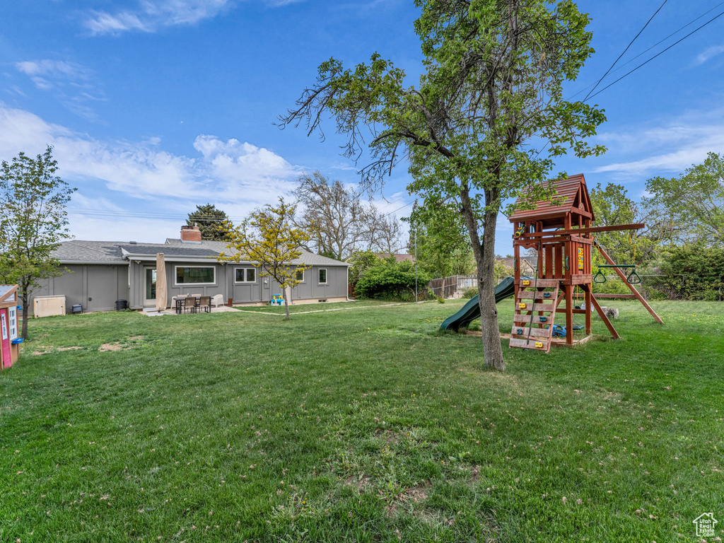 View of yard with a playground and fence