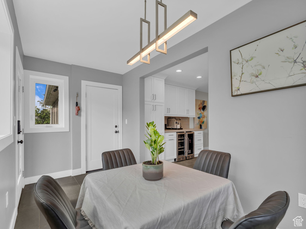 Dining space with baseboards, recessed lighting, dark tile patterned floors, and beverage cooler