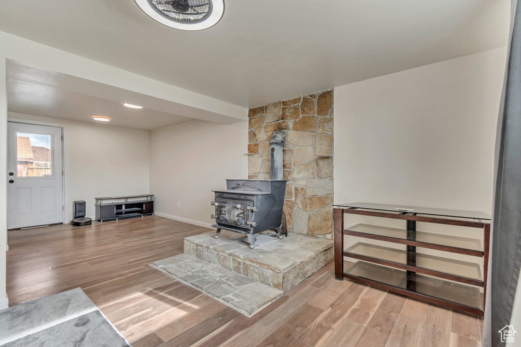 Living room with baseboards, wood finished floors, and a wood stove