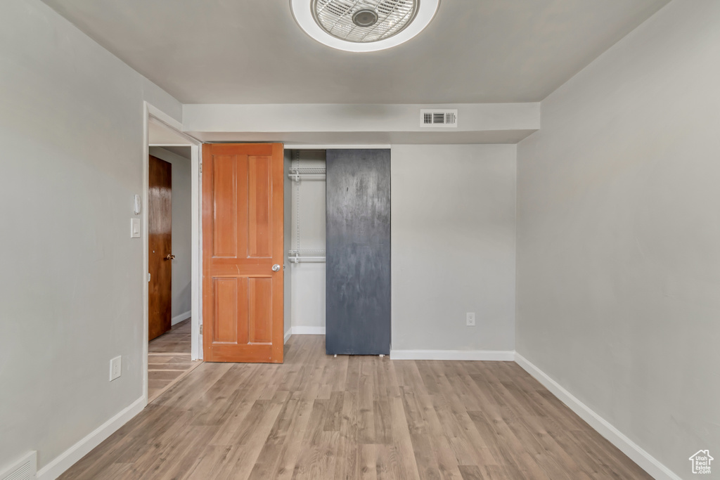 Unfurnished bedroom with visible vents, baseboards, and wood finished floors