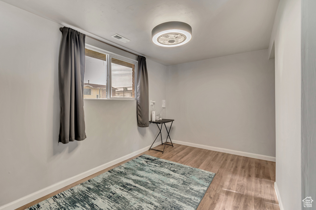 Unfurnished room with visible vents, baseboards, and wood finished floors