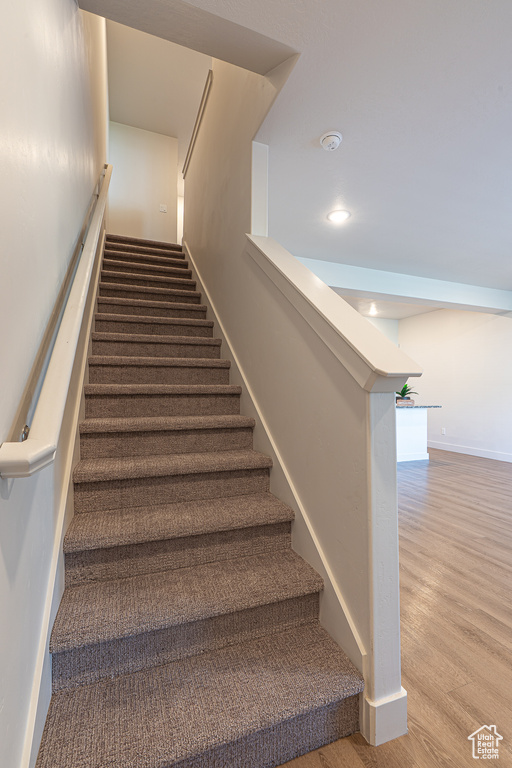 Staircase featuring baseboards and wood finished floors